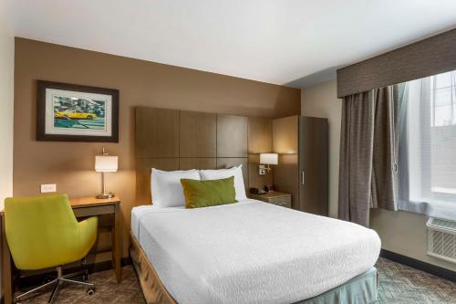 a hotel room with a bed and a yellow chair at Best Western Brooklyn-Coney Island Inn in Brooklyn