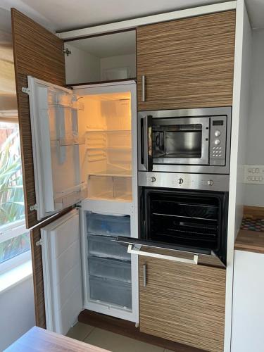 a kitchen with an open refrigerator and a microwave at Holiday Home In Cardiff, Sleeps 8 in Cardiff