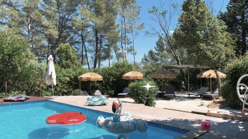 a swimming pool with chairs and umbrellas in a yard at La Villa Tosca in Callas