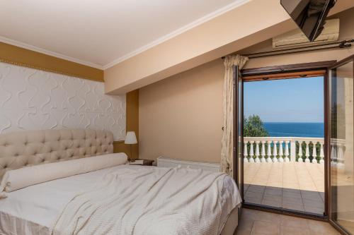 a bedroom with a bed and a view of the ocean at Villa Napolia in Zakynthos