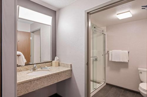 a bathroom with a sink and a toilet and a mirror at Sonesta Select Pleasant Hill in Pleasant Hill