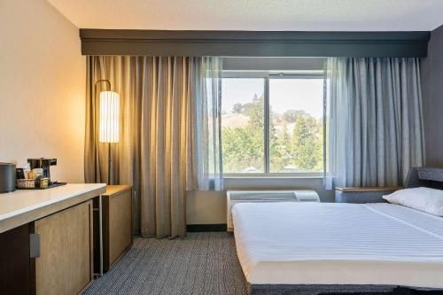 a hotel room with a bed and a window at Sonesta Select Pleasant Hill in Pleasant Hill