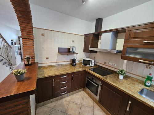 - une cuisine avec des placards en bois et un comptoir dans l'établissement Casa el albaicin, à Alhaurín el Grande