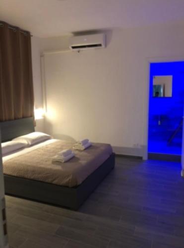 1 dormitorio con 1 cama y puerta azul en Fuori Ortigia Room 2, en Siracusa