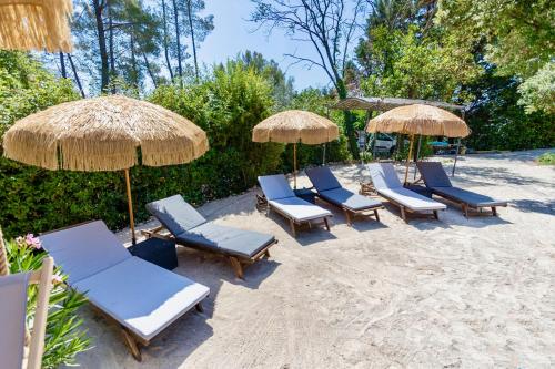 a group of lounge chairs and umbrellas on the beach at La Villa Tosca in Callas