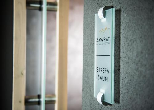 a sign on the side of a wall at Hotel ZAWRAT Ski Resort & Spa in Białka Tatrzanska