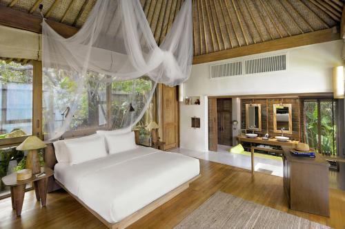 a bedroom with a white bed and a desk at Six Senses Samui in Choeng Mon Beach