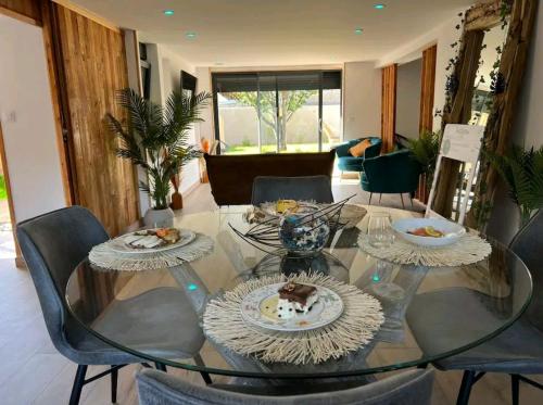 une table en verre avec des assiettes de nourriture dessus dans l'établissement ESCAPE ZEN Oasis tropicale & Spa privatif, à Loon-Plage