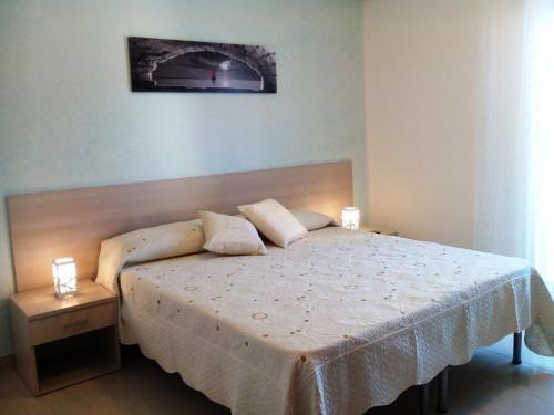 a bedroom with a bed with two lamps on it at B&B Trullo di Mare in Torricella