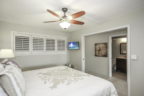een slaapkamer met een plafondventilator en een bed bij Kuhio Shores 208 in Koloa