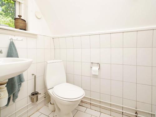 Baño blanco con aseo y lavamanos en Holiday home Frederiksværk XXIV, en Frederiksværk