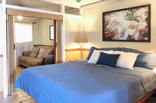 een slaapkamer met een blauw bed en een bank bij Kuhio Shores 207 in Koloa
