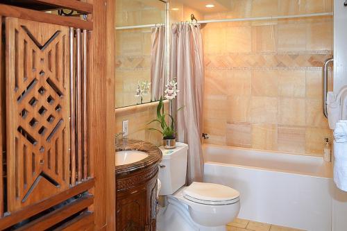 een badkamer met een toilet, een wastafel en een bad bij Kuhio Shores 207 in Koloa
