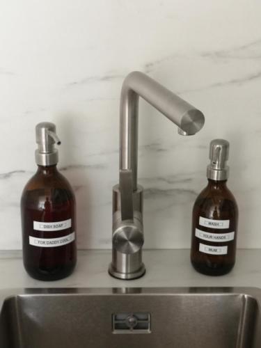 a sink with two bottles of soap and a faucet at Westeinders Sea View in Middelkerke
