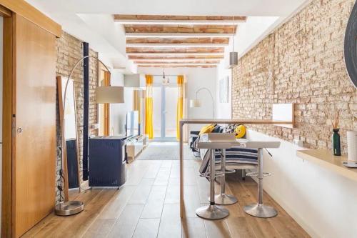 ロスピタレート・デ・リョブレガートにあるSweet Room Barcelonaのレンガの壁、テーブルと椅子付きのキッチンが備わります。