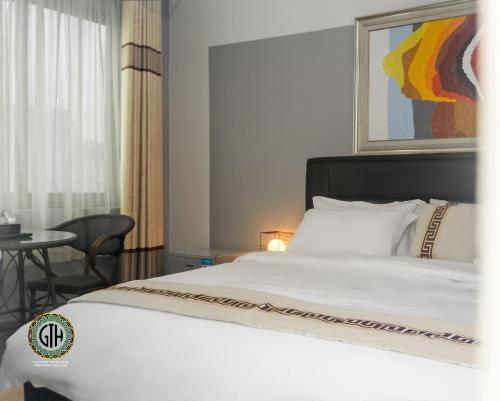 ApenkwaにあるGullivers Travel Hotelのベッドルーム(白いベッド1台、テーブル付)