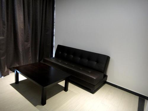 a black leather couch and a table in a room at Galaxy Hotel SIMPANG AMPAT in Simpang Ampat