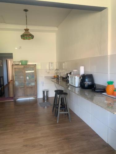 a kitchen with a counter and a counter top at Pousada GigiRetrô Catas Altas-MG in Catas Altas