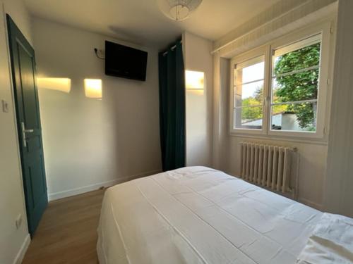 um quarto com uma cama branca e uma janela em Les gîtes de Mazélise em Mazerolles