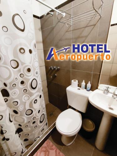 a hotel bathroom with a toilet and a sink at Hotel AEROPUERTO Jujuy in Perico