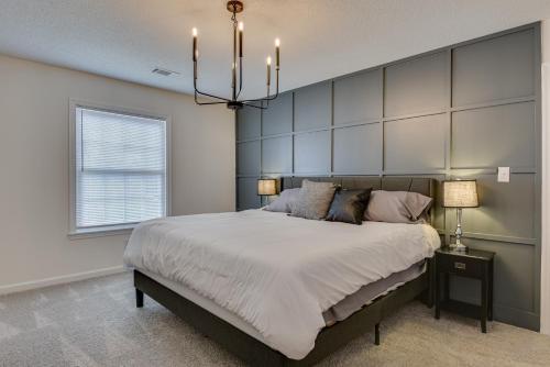 a bedroom with a large bed and a chandelier at Serene Sanctuary Near I-20 in Augusta
