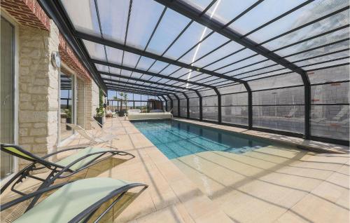 an indoor swimming pool with a retractable roof at Le Loft De La Grange in Léglantiers