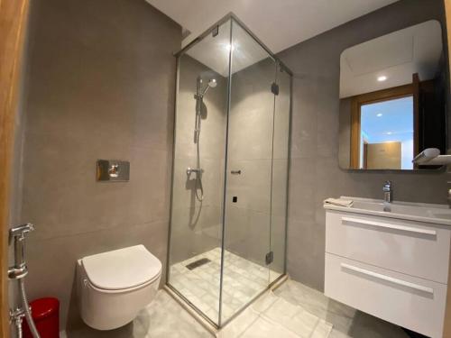 a bathroom with a shower and a toilet and a sink at Corniche Casablanca - Black New in Casablanca