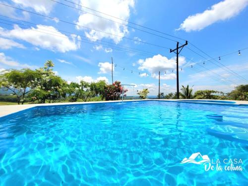 una piscina en una villa con cielo azul y nubes en Vista al Volcán Tenorio y Montaña en San Rafael