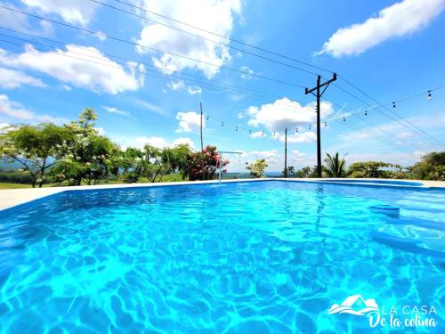 a large swimming pool with blue water at Vista al Volcán Tenorio y Montaña in San Rafael
