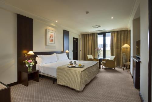 a hotel room with a large bed and a desk at Exe Oviedo Centro in Oviedo