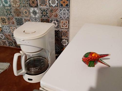 a white coffee maker sitting on top of a toilet at Bungalow La Media Luna Brisas de Zicatela in Brisas de Zicatela