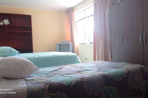 a bedroom with two beds and a window at casa hospedaje regina marie in Huaraz