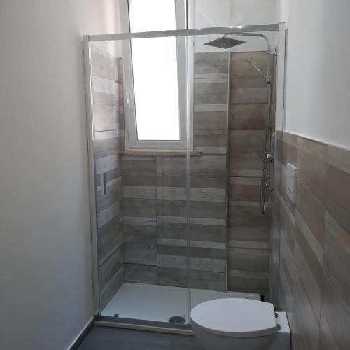 a bathroom with a shower with a toilet and a window at Fuori Ortigia Room 2 in Siracusa