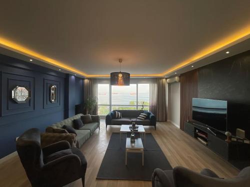 uma sala de estar com sofás e uma televisão de ecrã plano em Mükemmel Deniz Manzaralı Lüks em Istambul