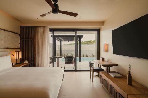 a bedroom with a bed and a flat screen tv at Nobu Hotel Los Cabos in Cabo San Lucas