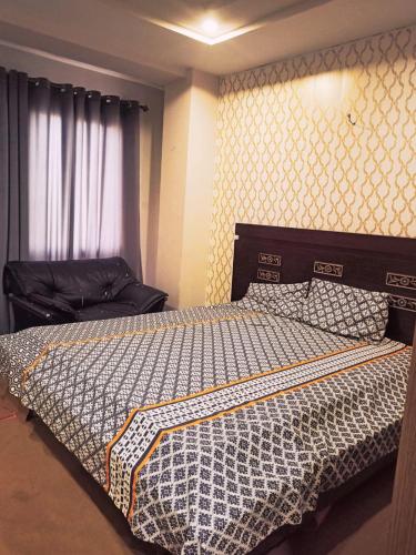 een slaapkamer met een bed met een dekbed erop bij Bahria town islamabad in Rawalpindi
