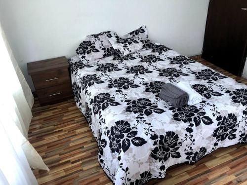 a black and white bed with a black and white comforter at Hermosa Cabaña Campestre Puente Boyacá in Ventaquemada