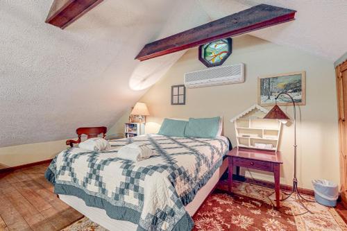 a bedroom with a bed and a table with a chair at Kinnikinnick in Glen Arbor