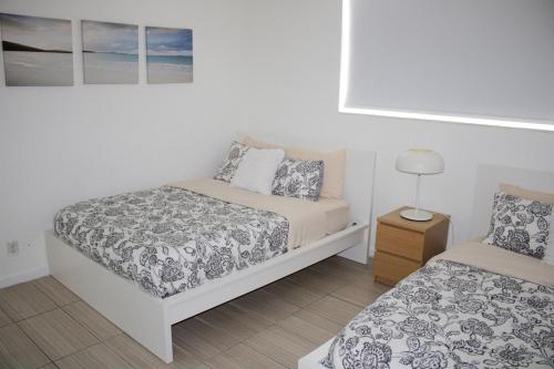 Dormitorio pequeño con 2 camas y lámpara en Breathtaking Beach Condo!!!, en Hollywood