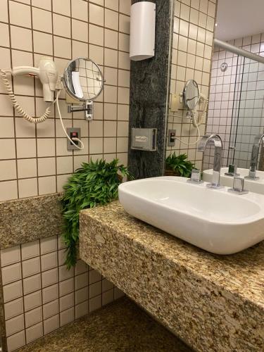 a bathroom with a sink and a mirror at Sofisticado Flat Particular Grand Mercure in Brasilia