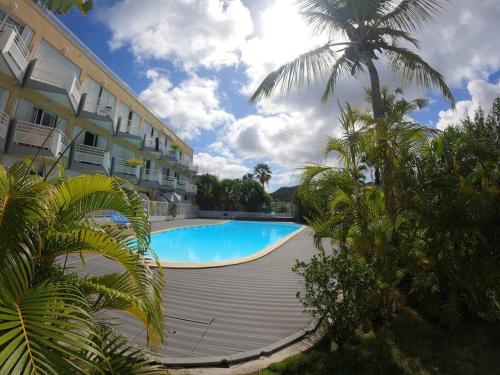 a large swimming pool in front of a building at Appartement piscine et plage privée ! in Marigot