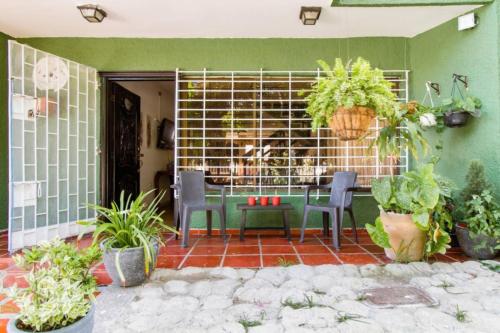 un patio con mesa, sillas y plantas en Casa Verde El Golf, en Barranquilla