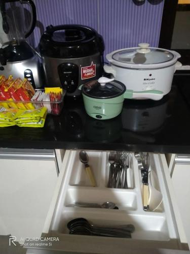 a kitchen sink with two measuring cups and a pot at Vimala Hills FARLA Villa - 3BR in Gadok 1