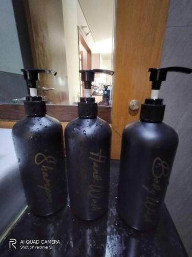 two blue bottles sitting on a counter in front of a mirror at Vimala Hills FARLA Villa - 3BR in Gadok 1