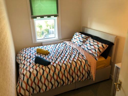 a bedroom with a bed with a comforter and a window at The Burnham House in Bath