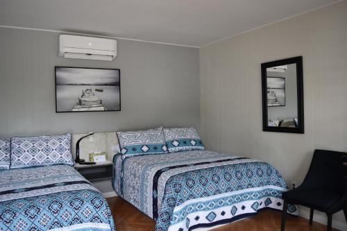 a bedroom with two beds and a mirror at Motel de L'Anse et Camping Rimouski in Rimouski