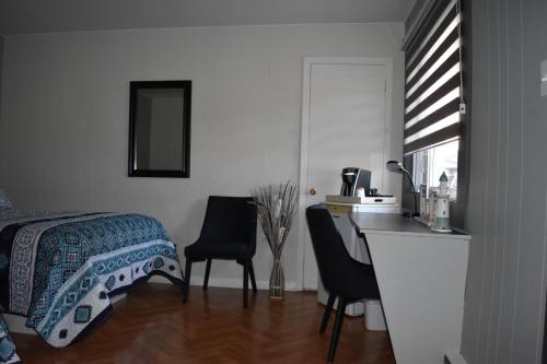 a bedroom with a bed and a desk and chairs at Motel de L'Anse et Camping Rimouski in Rimouski