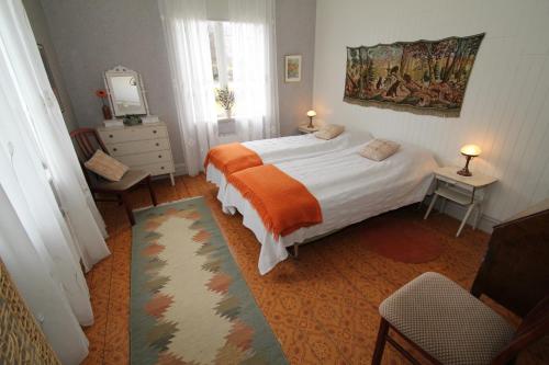 a bedroom with a bed with an orange blanket at Villa Fridhem, Härnösand in Härnösand