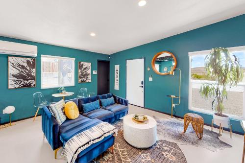 a blue living room with a blue couch and a table at Unique Hideaway in Joshua Tree