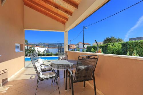 un patio con tavolo e sedie sul balcone. di Luxury villa with a swimming pool Plano, Trogir - 18490 a Trogir